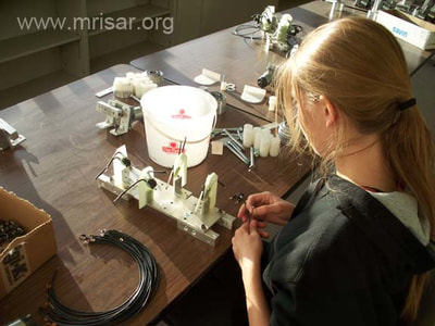 MRISAR's R&D Team member Autumn assembling robotic arms.