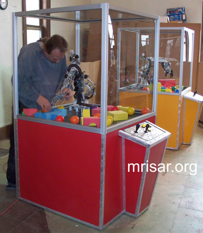 MRISAR's Team member installing our base mounted 5 and 3 Finger Robotic Arms into the exhibit cases we made. We have been making exhibit robotics since 1991.