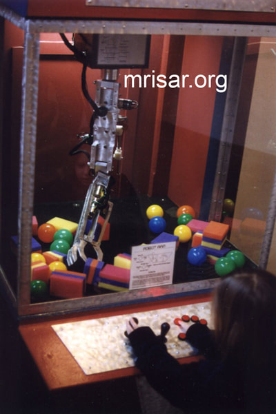 Robotic Exhibits; The early version (2001) of MRISAR's Top mounted 5 Finger Robotic Arm Exhibit. Testing it are MRISAR Team members Autumn and Aurora Siegel. They are the youngest members of the MRISAR team and began their apprenticeship as preschoolers. MRISAR has designed and fabricated the earth’s largest selection of world-class, public use, interactive robotic exhibits.