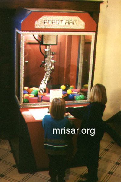 Robotic Exhibits; The early version (2001) of MRISAR's Top mounted 5 Finger Robotic Arm Exhibit. Testing it are MRISAR Team members Autumn and Aurora Siegel. They are the youngest members of the MRISAR team and began their apprenticeship as preschoolers. MRISAR has designed and fabricated the earth’s largest selection of world-class, public use, interactive robotic exhibits.