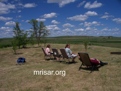 Seen here are MRISAR R&D Team members Aurora, Autumn and John Siegel taking a break shortly after relocating here. During the first 3 years after relocating, MRISAR’s Team hand-planted over 4,000 edible and medicinal trees and shrubs on the 10 acre grounds at our North Dakota Complex.